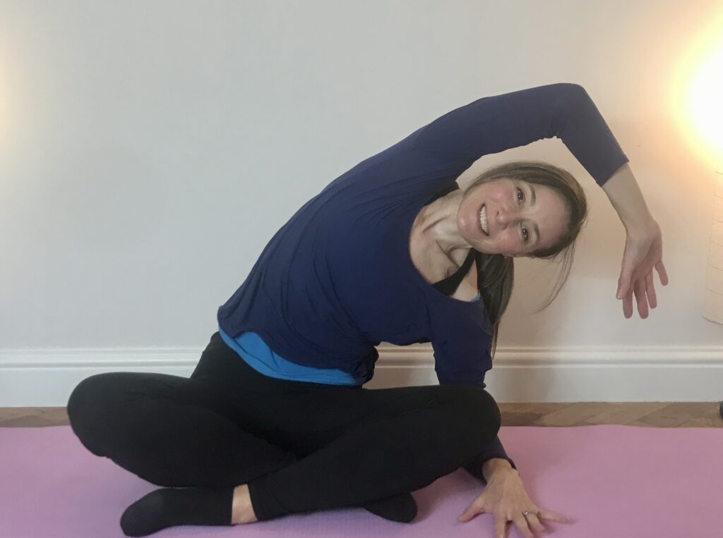 Jo doing Pilates exercise seated side bend